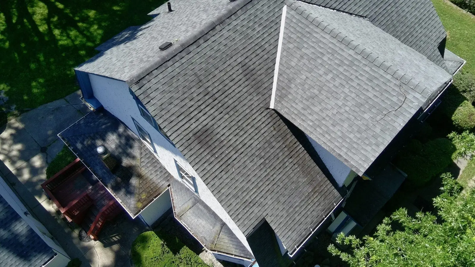 Aging asphalt shingle roof with dark streaking and worn shingles
