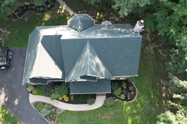 Aerial view of a completed architectural shingle roof on a wooded lot in the Chagrin Valley