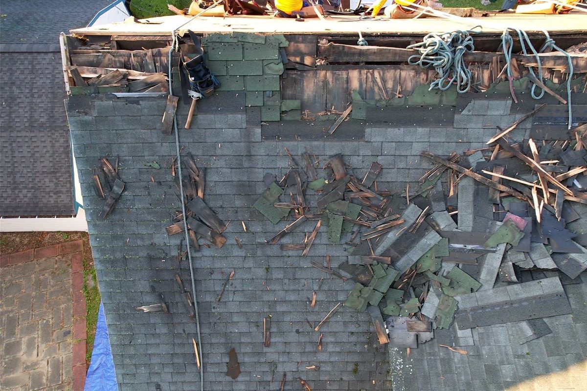 Old, deteriorated asphalt shingles torn up during a roof replacement