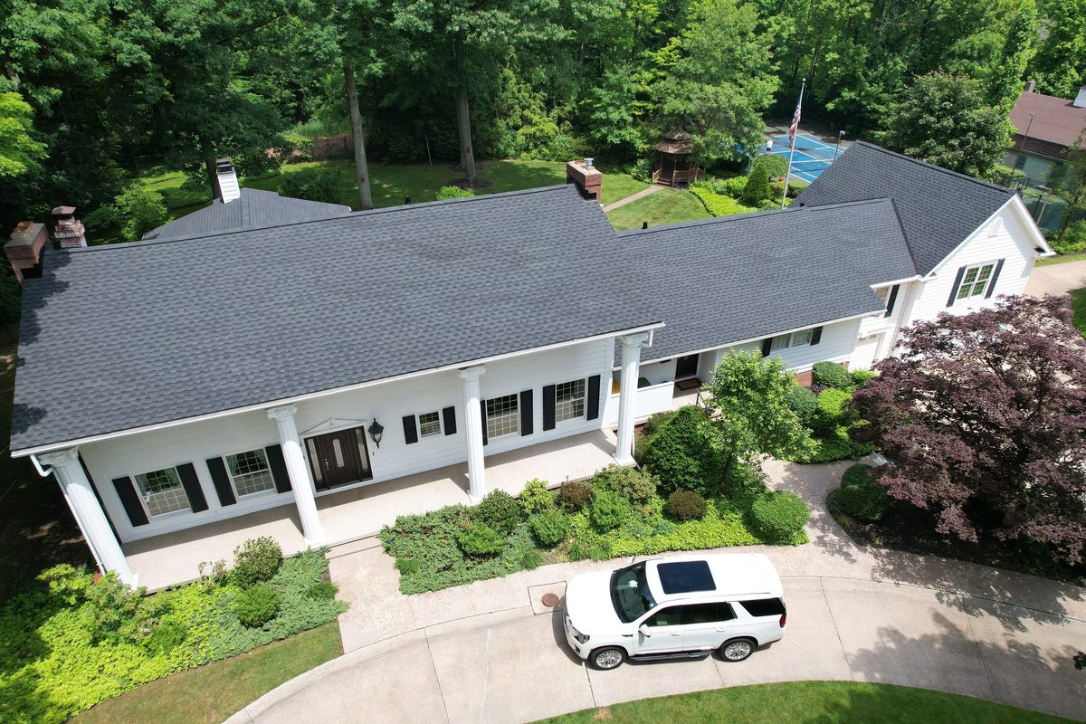 White colonial-style home with a new charcoal architectural shingle roof in Northeast Ohio
