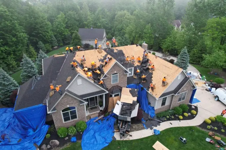 RAW Roofing Solutions crew replacing the roof on a large brick home on a wooded lot