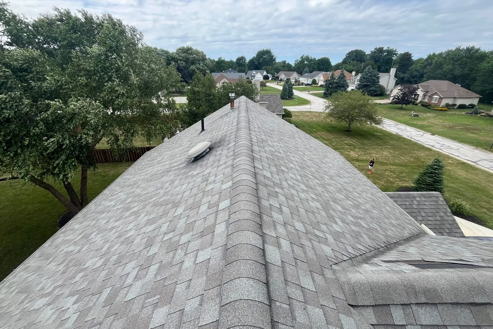 Wind-lifted asphalt shingles along the lower edge of a roof section on a Northeast Ohio home