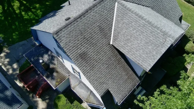 Aging asphalt shingle roof with dark streaking and worn shingles