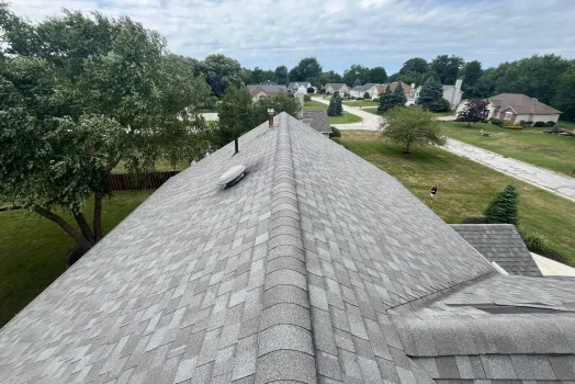 Wind-lifted asphalt shingles along the lower edge of a roof section on a Northeast Ohio home